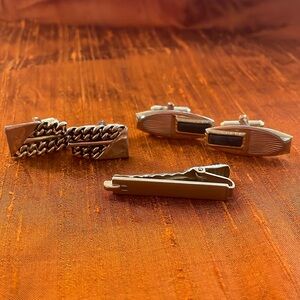 Two cuff links and one tie clip. Gold tone